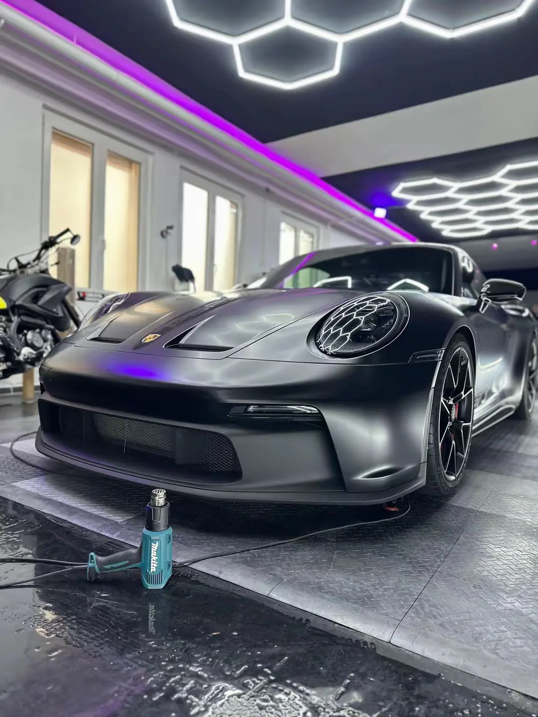 Porsche 911 GT3 in Mattgrau von vorne unter Wabenlicht