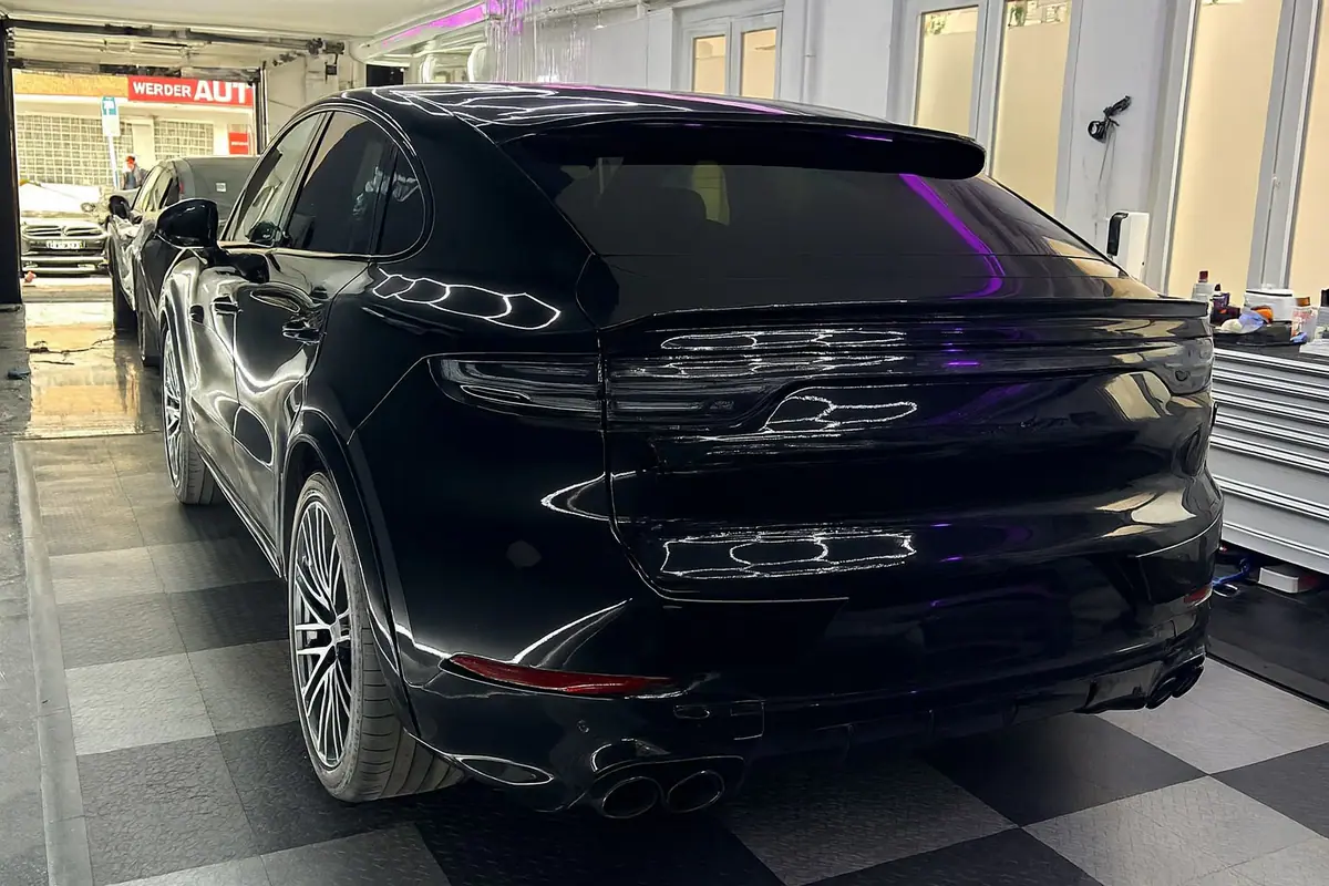 Heck eines schwarzen Porsche Cayenne Coupé mit dunklen Scheiben