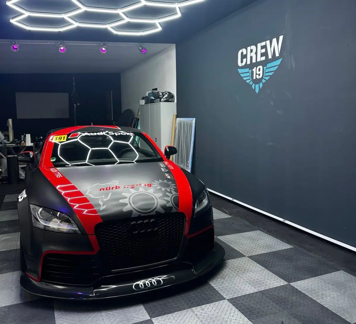 Audi mit Rot-Schwarz-Design vor dem CREW-19-Logo