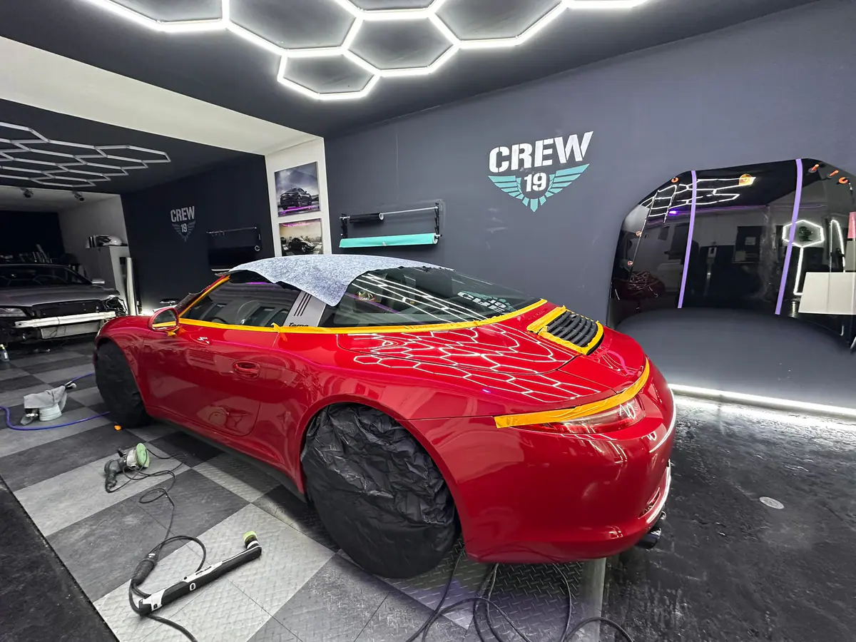 Roter Porsche 911 mit gelben Designstreifen in Arbeit