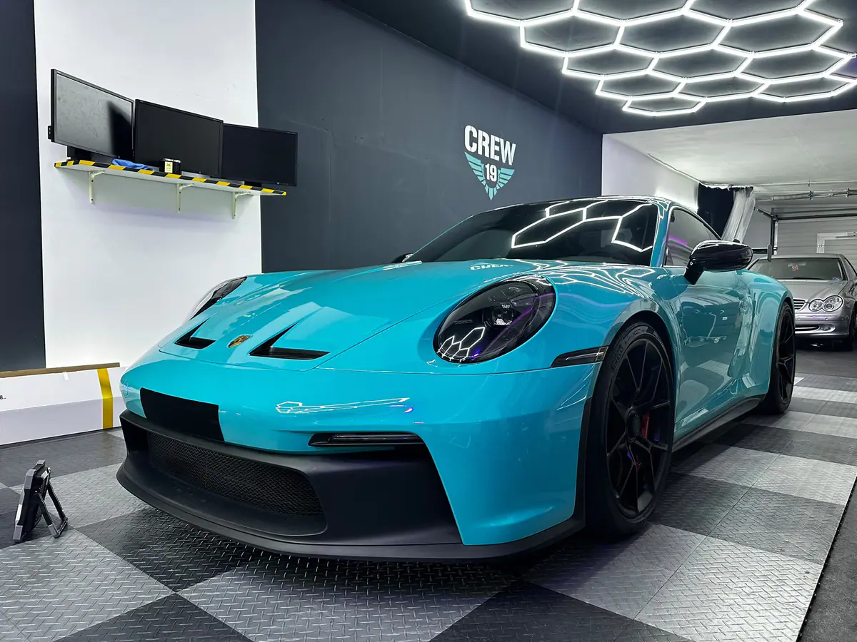 Türkiser Porsche 911 GT3 von vorne in der CREW-19-Werkstatt